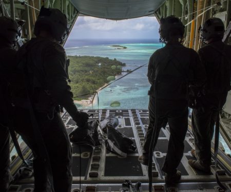 Loadmasters with the 36th Airlift Squadron out of Yokota AB, Japan, watch as humanitarian assistance bundles they just airdropped parachute down to those in need during Operation Christmas Drop 2019, at Nomwin, Federated States of Micronesia, Dec. 13, 2019. Air Force photo by SrA. Matthew Gilmore.